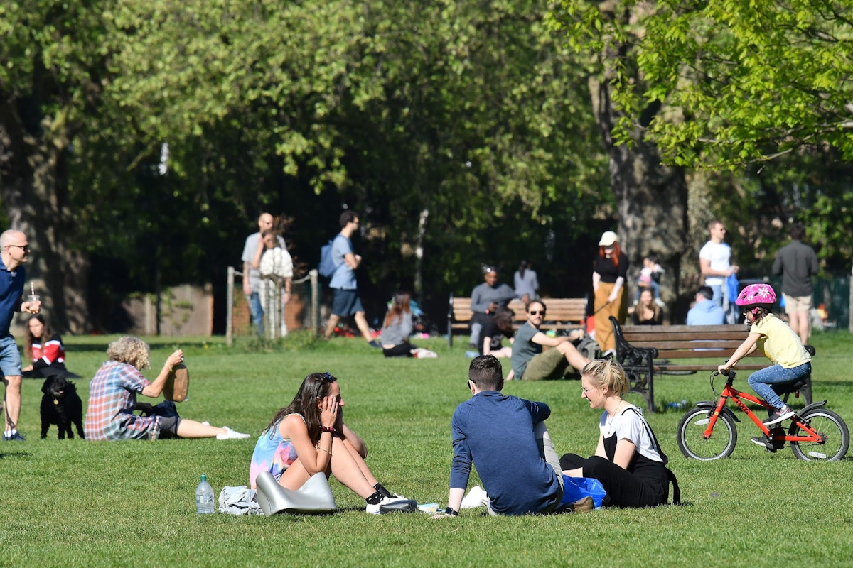 People enjoy the sping sunshine in London Fields park in east London on April 25, 2020, during the national lockdown due to the novel coronavirus COVID-19 pandemic. - Boris Johnson's government on Saturday was embroiled in a political row after it emerged his chief advisor attended meetings of the main scientific group advising ministers on the coronavirus pandemic in Britain. Downing Street was forced to deny that Dominic Cummings and another advisor, Ben Warner, were members of the politically independent Scientific Advisory Group for Emergencies (SAGE). (Photo by JUSTIN TALLIS / AFP) - AFP