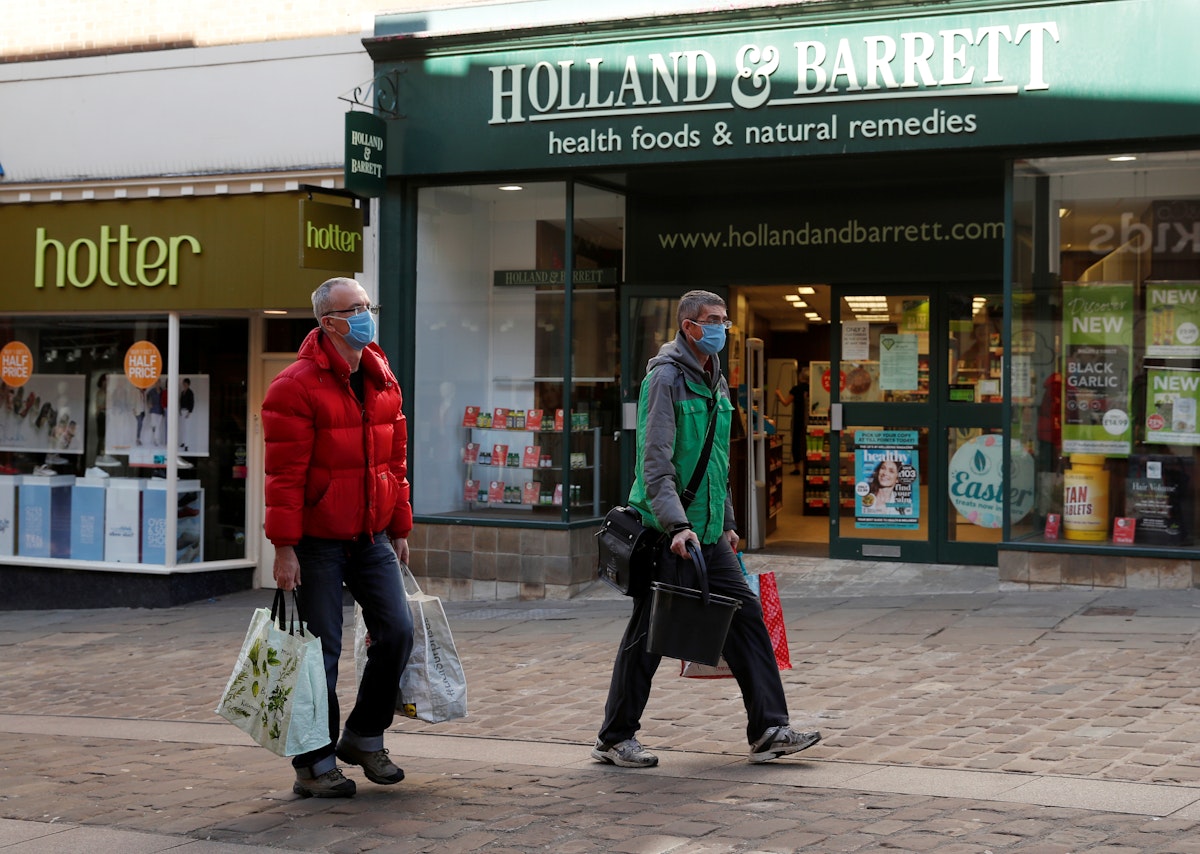 يظهر الأشخاص الذين يرتدون أقنعة واقية للوجه خارج متجر Holland & Barrett في دورهام ، مع استمرار انتشار مرض فيروس كورونا (COVID-19) ، دورهام ، بريطانيا - REUTERS